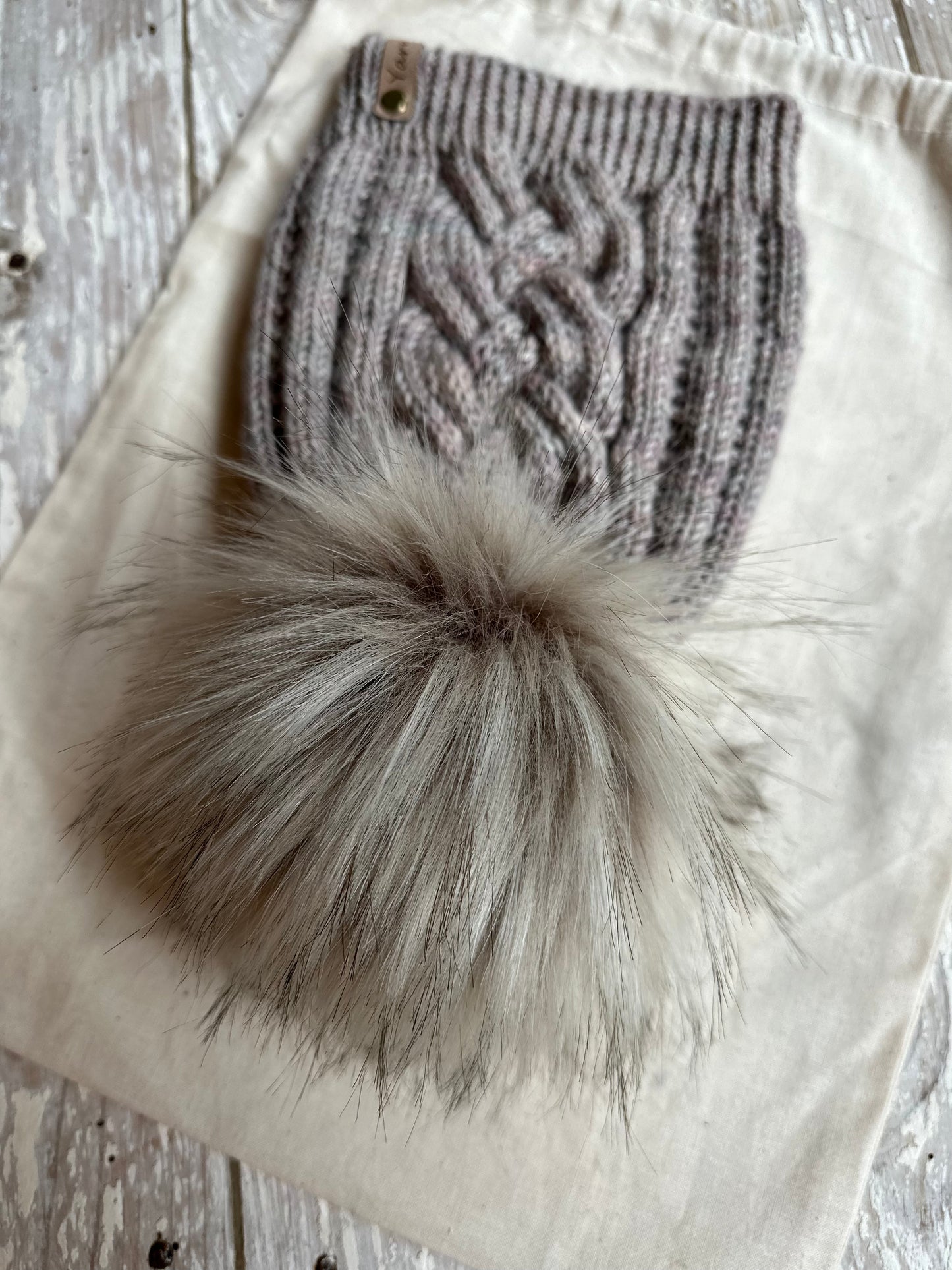 Merino wool cable knit hat with faux fur pom