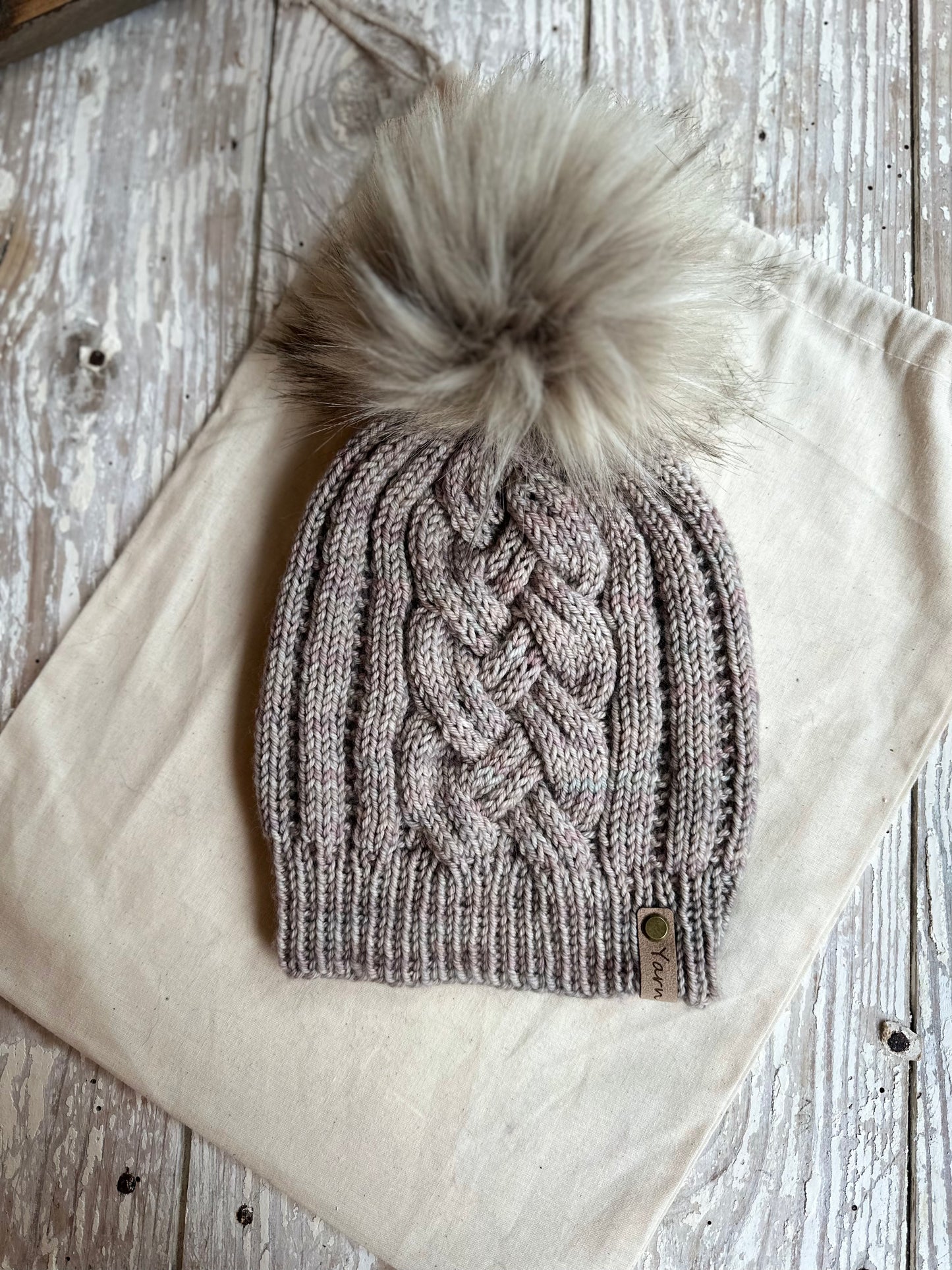 Merino wool cable knit hat with faux fur pom