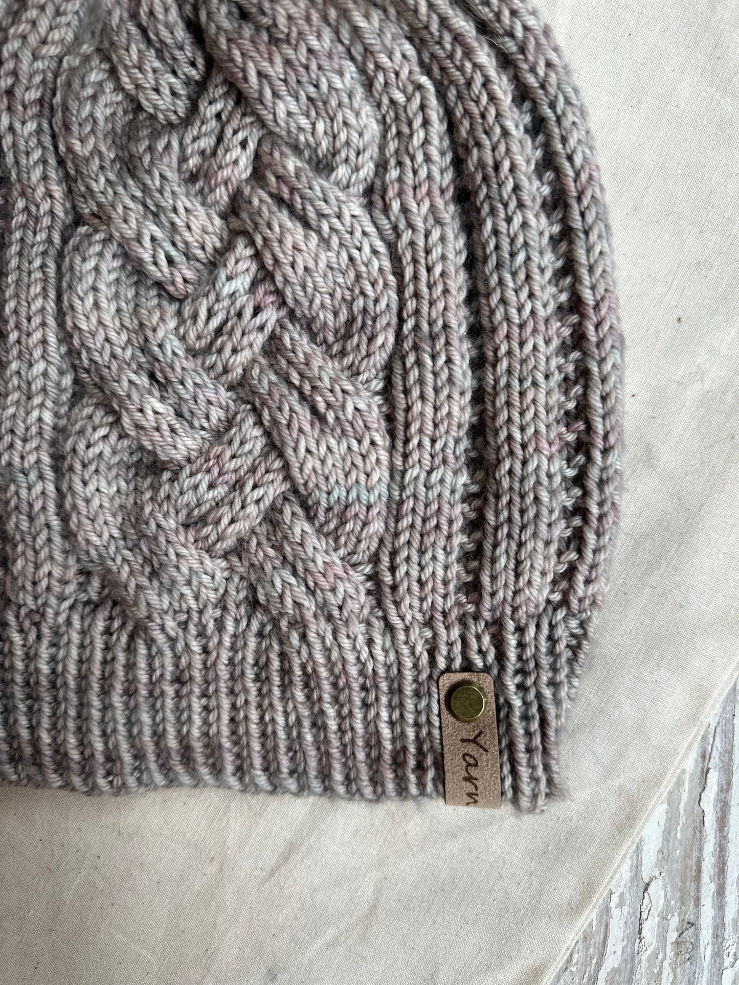 Merino wool cable knit hat with faux fur pom